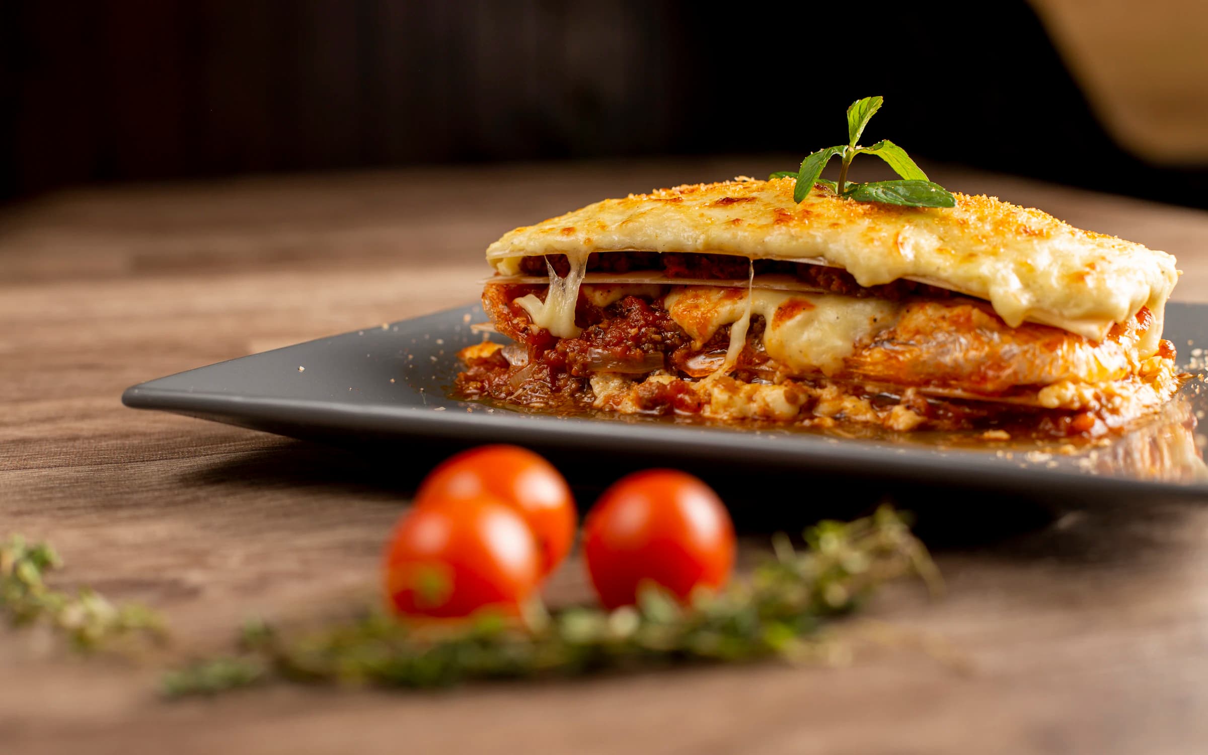 Ein Stück Lasagne mit geschmolzenem Käse und Tomaten