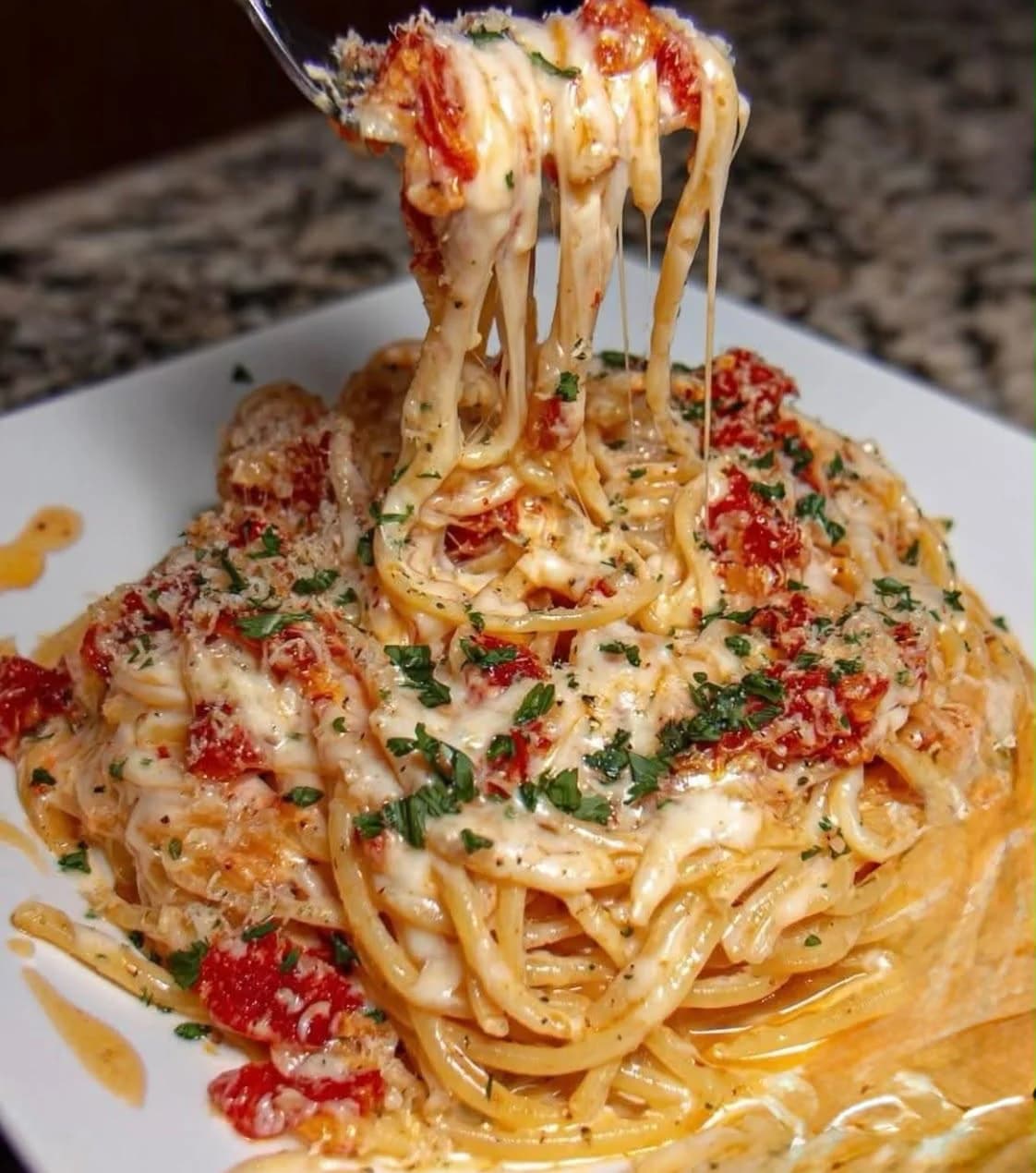 Spaghetti mit Tomaten und Käse auf der Gabel