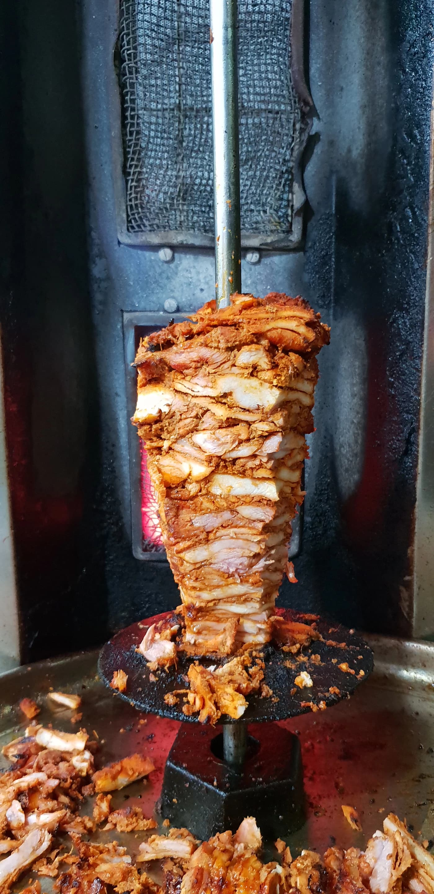 Döner-Fleisch dreht sich am Spieß vor dem Grill