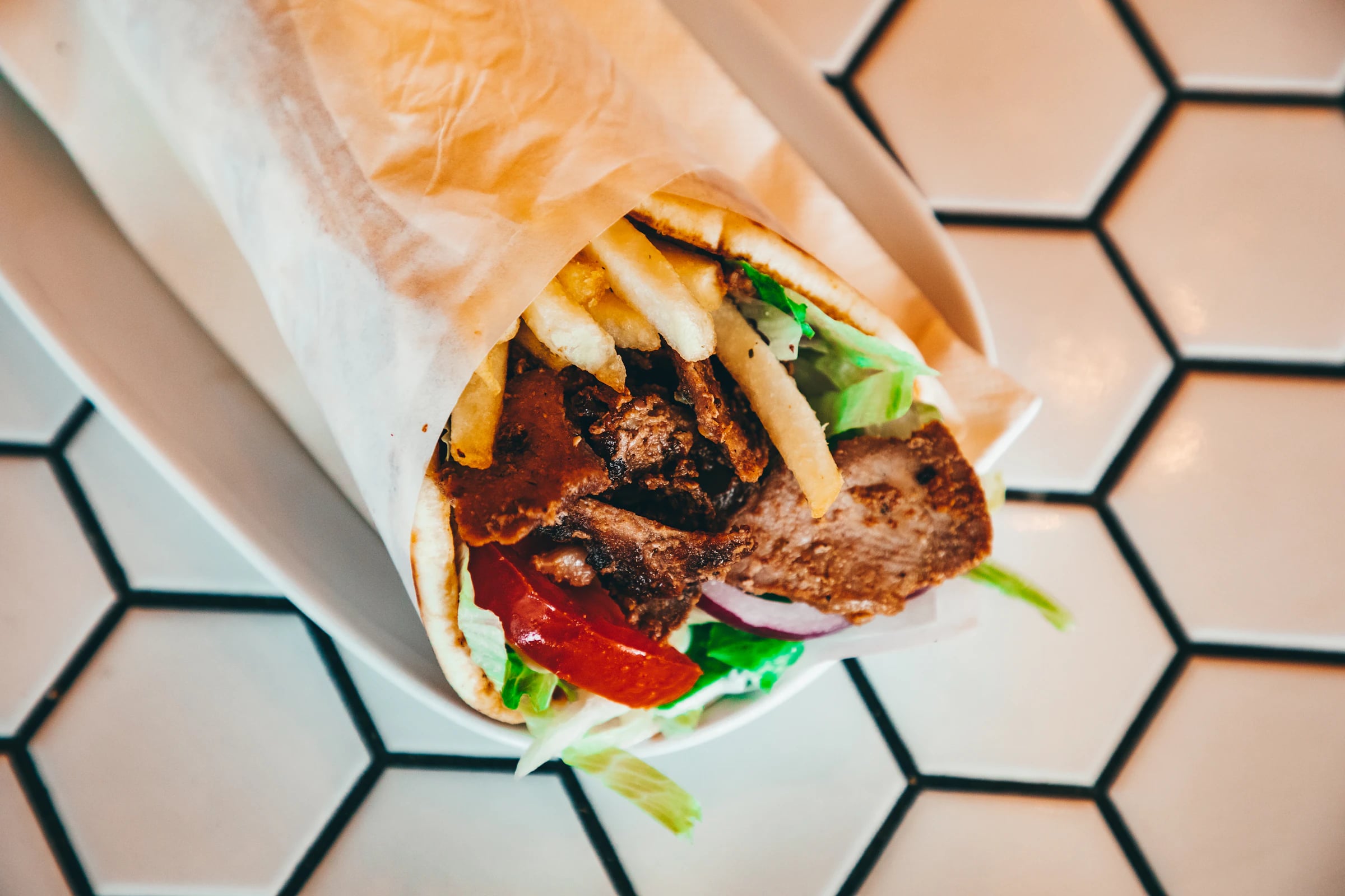Gerollter Dürüm mit Fleisch und Salat in Papier