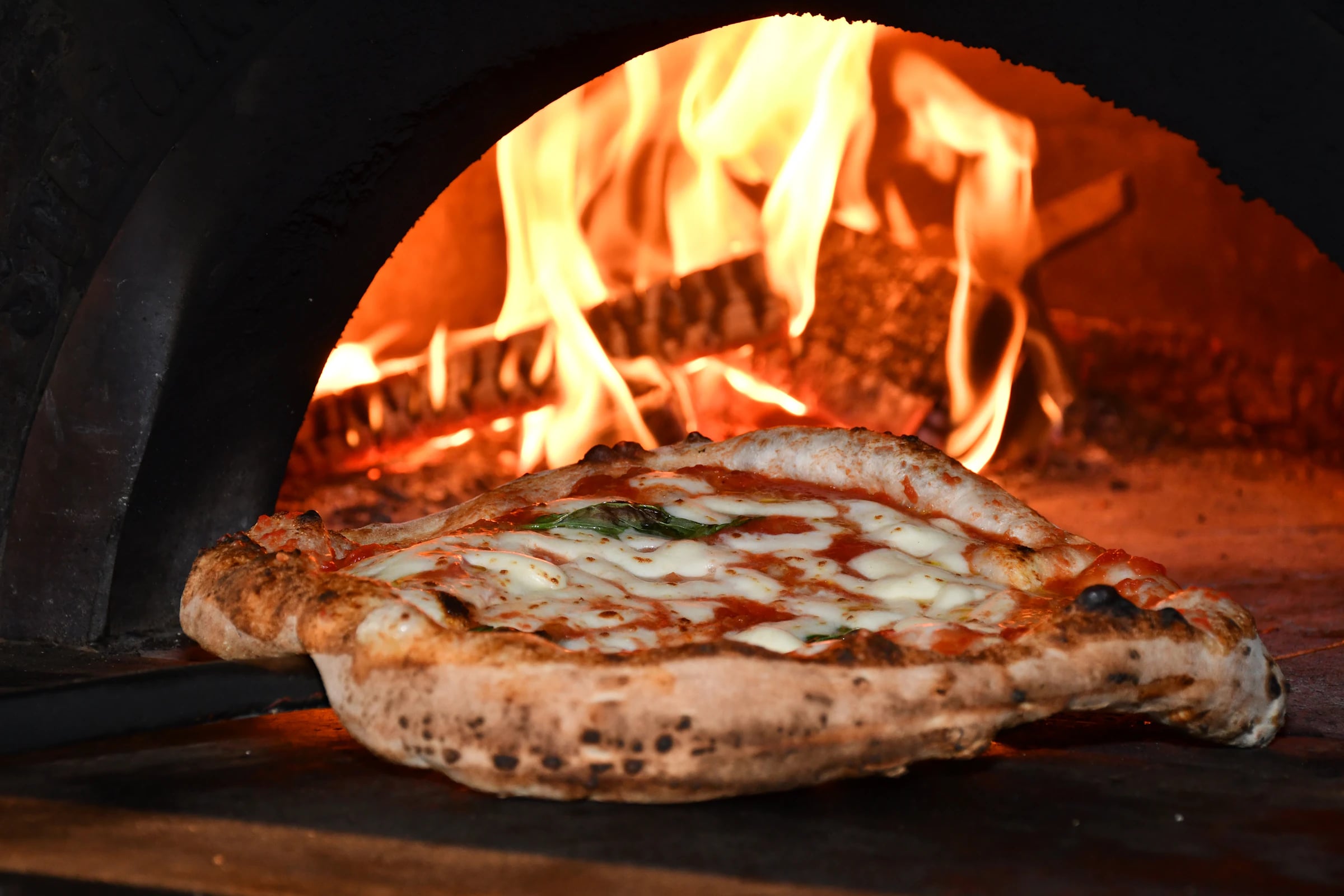 Pizza beim Backen im heißen Holzofen