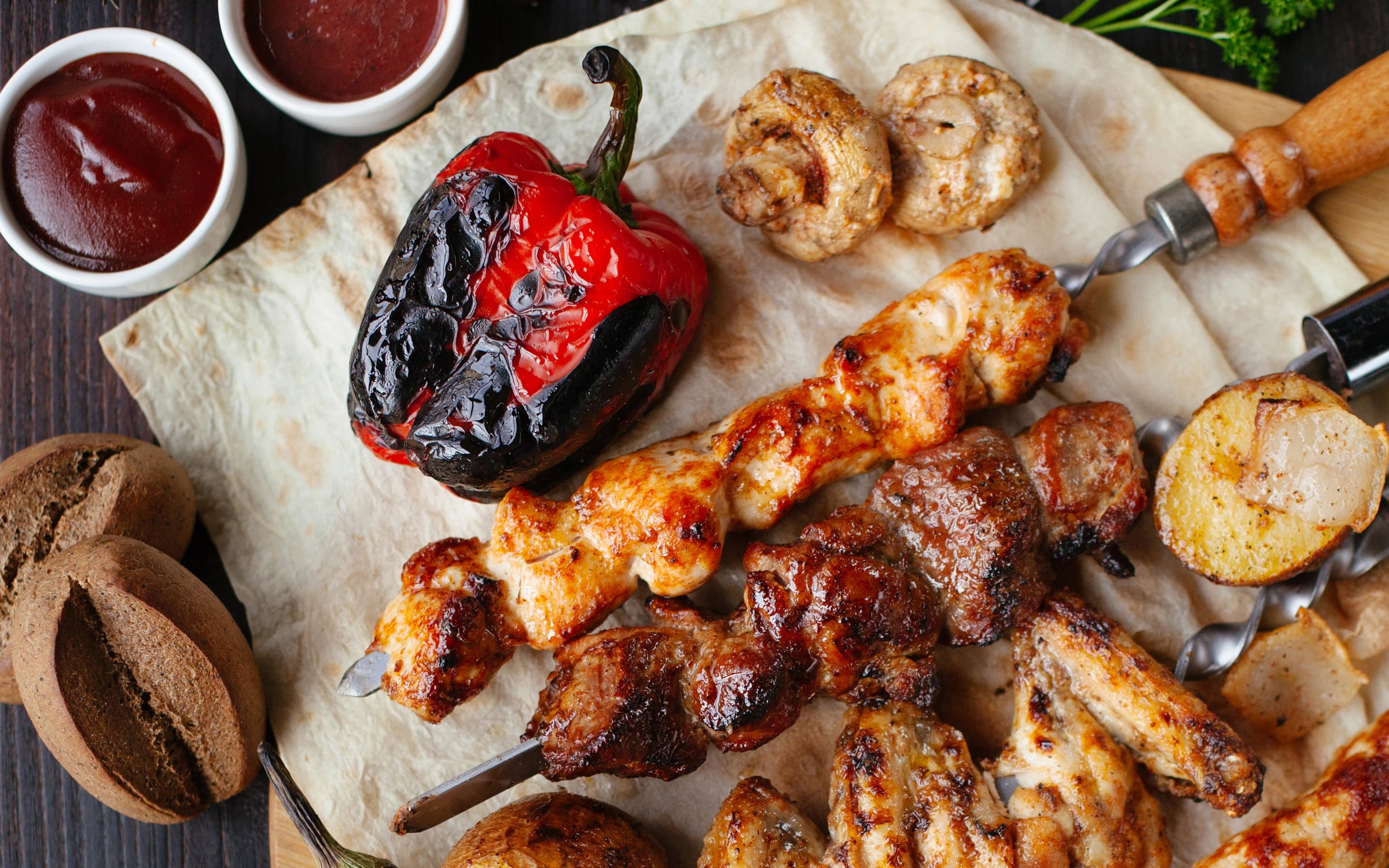 Gegrilltes Fleisch, Paprika und Saucen auf Fladenbrot